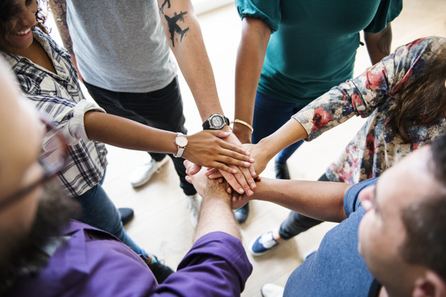 Group of diverse people joined hands together teamwork